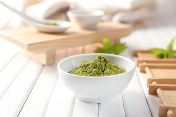 Bowl with powdered matcha green tea on table