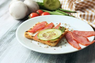 Plate with delicious toast on wooden table