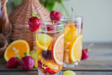 Homemade refreshing fruit sangria or punch with champagne, strawberries, oranges and grapes.