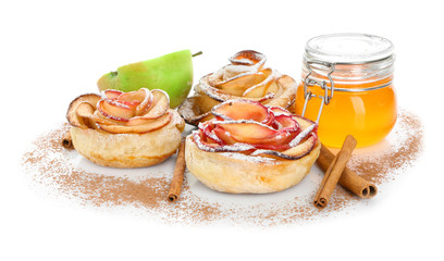 Tasty rose shaped apple pastry with cinnamon and honey on white background