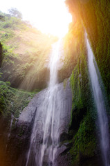 Fototapeta na wymiar Madakaripura Waterfall with sunlight effect is the tallest waterfall in deep forest in Java and the second tallest waterfall in Indonesia