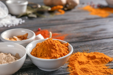 Bowls with various spices on wooden table