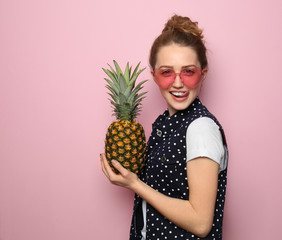Portrait of beautiful young woman with pineapple on color background