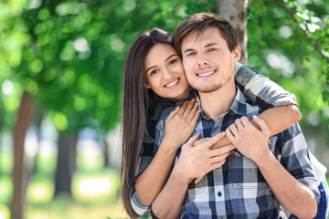 Fototapeta premium Portrait of happy young couple in green park