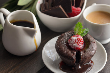 Close up  of  Coulant or Chocolate fondant with raspberry, mint  and powdered sugar. Delicious french dessert
