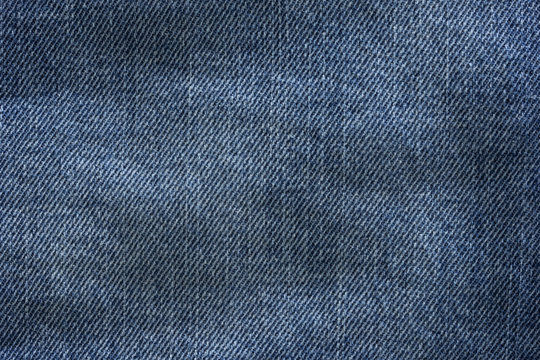 Old blue denim jeans texture or background with visible fibers