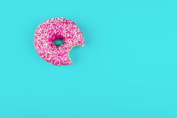 Minimalism, colour contrast on a blue background, donut photo from above in flat style