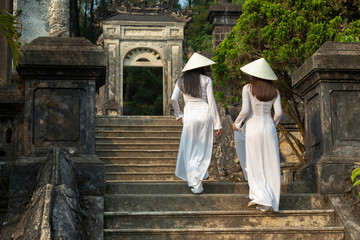 Traditionally dressed young vietnamese women in Royal Tumb of Khai Dinh King in Hue city,  Vietnam