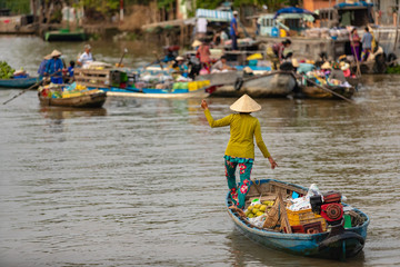 Fototapeta na wymiar Boat woman in floating market in Mekong River, Vietnam