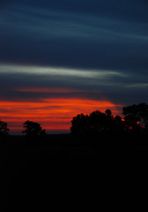 Bright red and blue summer sunset in the village