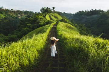 Rolgordijnen Jonge mooie vrouw lopen op Campuhan Ridge manier van kunstenaars, in Bali, Ubud. Mooie rustige zonnige ochtend © Oleg Breslavtsev