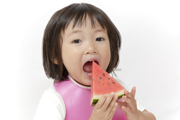 スイカを持ち大きな口を開ける幼い女の子