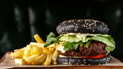 Vegetarian black burger with cutlet peas falafel, tomato, cucumber, rucola salad and French fries....
