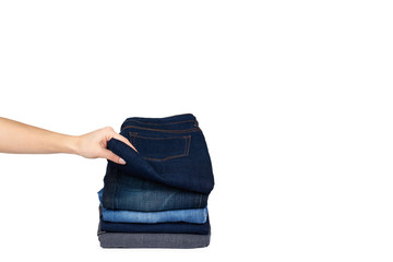 Foldet jeans in pile with hand, isolated on white background. copy space template