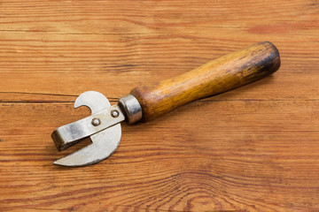 Old bottle and can opener on a rustic table