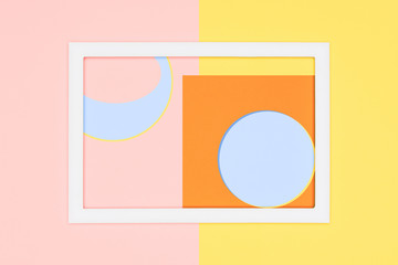 Abstract geometry flat lay pastel blue, pink and yellow paper texture minimalism background. Minimal geometric shapes and lines template with empty picture frame mock up.