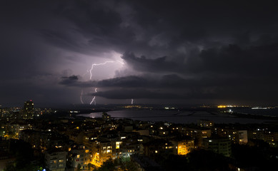 Spectacular Thunderstorm in dark night sky above city