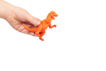 Prehistoric dinosaur rubber toy with kid hand, isolated on white background. copy space template