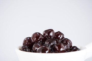 black pearls. Boiled tapioca pearls for bubble tea on white background. Copy space