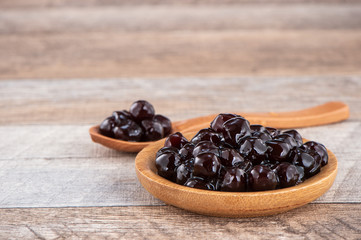 Tapioca Pearl , Bubble topping for tea or other beverage, in a cup, place on wooden table. Copy space