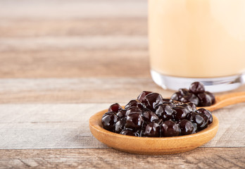 Tapioca Pearl , Bubble topping for tea or other beverage, in a cup, place on wooden table. Copy space