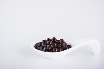 black pearls. Boiled tapioca pearls for bubble tea on white background. Copy space