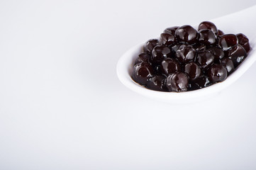 black pearls. Boiled tapioca pearls for bubble tea on white background. Copy space
