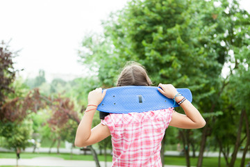 Girl being happy with her skateboard in the parkk 