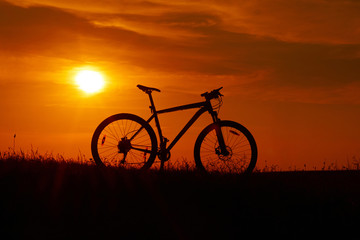 Silhouette of a bicycle on sunset background.