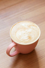 Pink coffee cup of cappuccino on the table