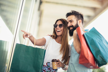 Beautiful couple enjoy shopping together, young couple holding shopping bags - Powered by Adobe