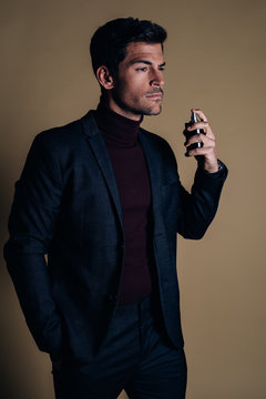 Young business man applying perfume