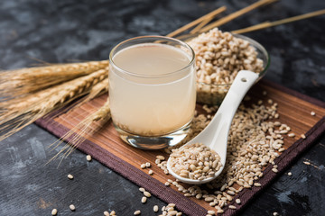 Barley water in glass with raw and cooked pearl barley wheat/seeds. selective focus