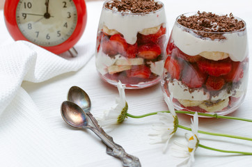 Strawberry dessert with chocolate chips, banana and sour cream in the glass.