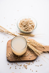 Barley water in glass with raw and cooked pearl barley wheat/seeds. selective focus