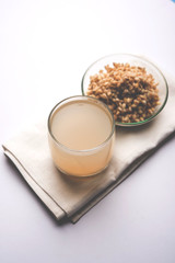 Barley water in glass with raw and cooked pearl barley wheat/seeds. selective focus
