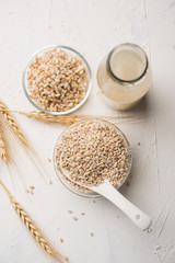 Barley water in glass bottle with raw and cooked pearl barley wheat/seeds. selective focus
