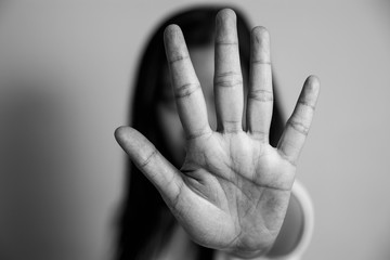 woman raised her hand for dissuade, campaign stop violence against women. Asian woman raised her hand for dissuade with copy space, black and white color - obrazy, fototapety, plakaty