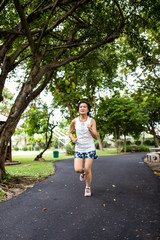 Asian woman jogging in the park, looking forward