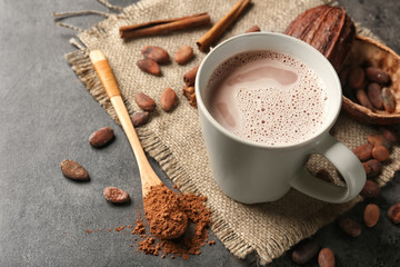 Cup of delicious hot cocoa on grey background