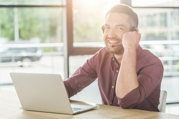 Fototapeta premium handsome young call center worker working at modern office and looking at camera