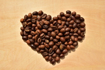 Coffee beans on wooden background. Valentines day. Heart. Coffee beans in ground coffee