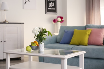 Naklejka premium Table with beautiful flowers in elegant interior of living room