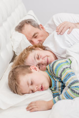 grandson sleeps with grandparents on the bed