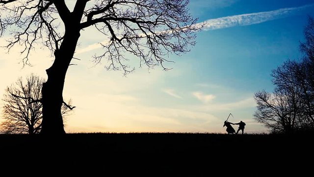 Grim Reaper came for a new victim and leads the victim to death. sunset silhouette. concept of death