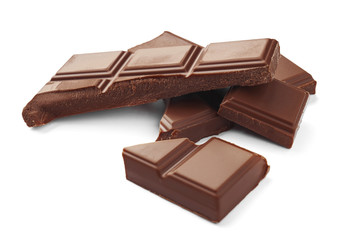 Delicious milk chocolate pieces on white background