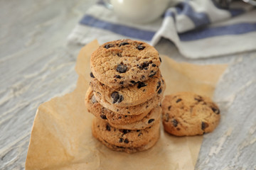 Delicious cookies with chocolate chips on light textured background