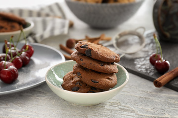 Plate with chocolate chip cookies on table
