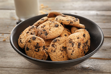 Plate with delicious chocolate chip cookies on wooden table