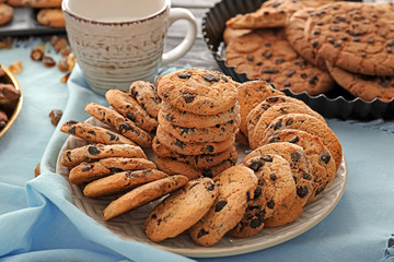 Plate with delicious chocolate chip cookies on table